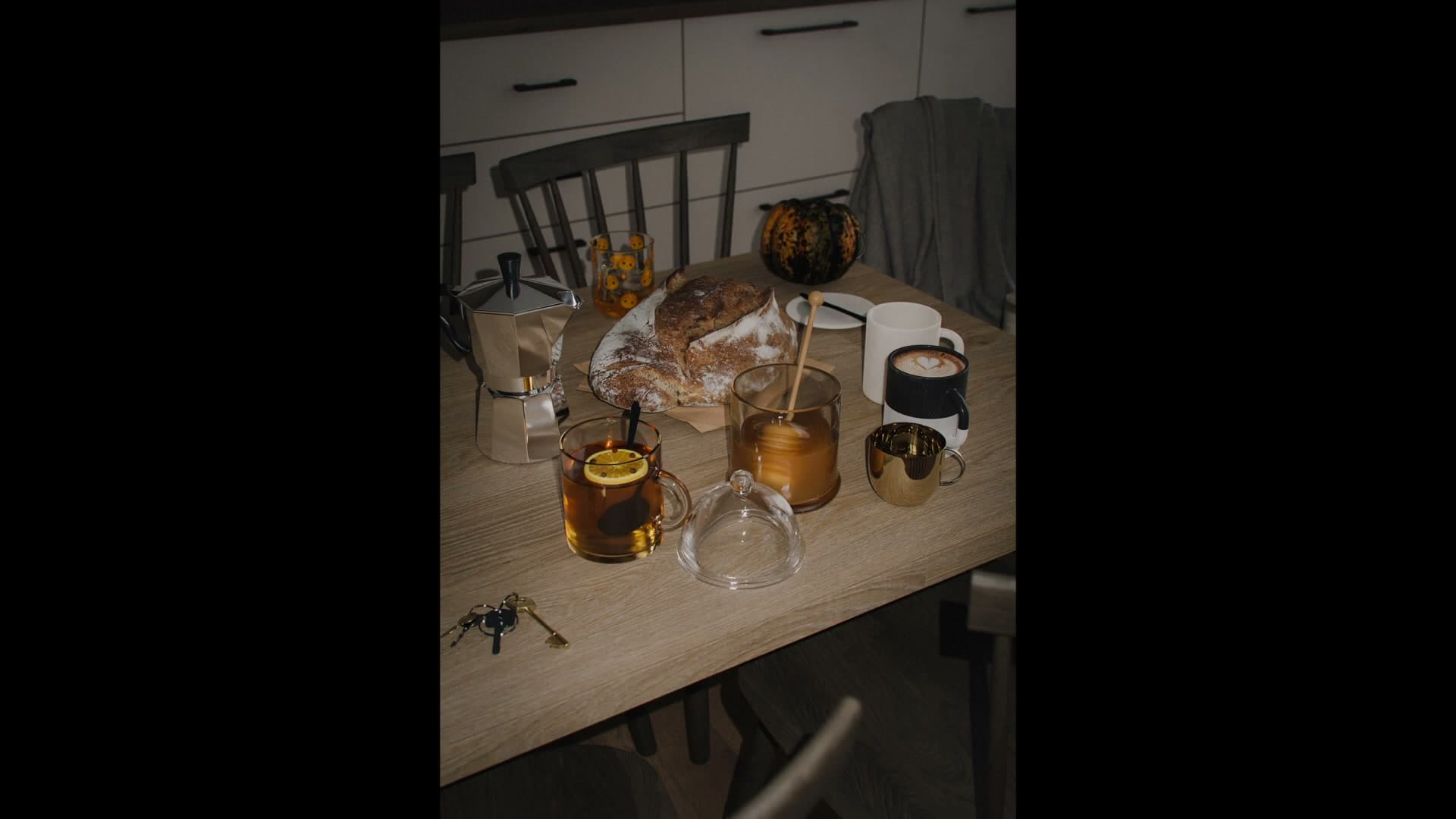 Drinks still full, bread untouched, room lit by something handheld. It reads like the occupants left in a hurry.
